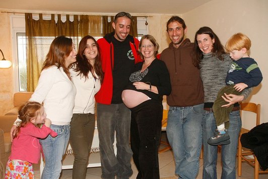 Ein Familienfoto, zwei Kinder, zwei Männer und vier Frauen sind zu sehen. Eine der Frauen ist schwanger