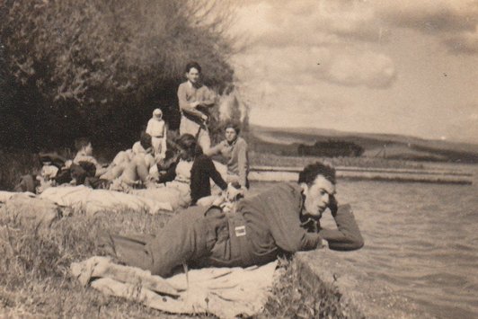 Ein junger Mann liegt am Seeufer