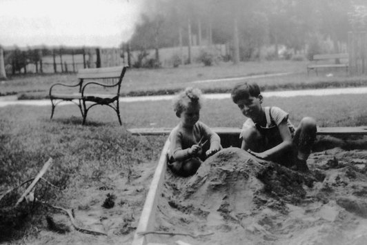 Zwei junge Kinder spielen in der Sandkiste in einem Park