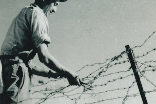 Ein Mann arbeitet mit Stacheldraht