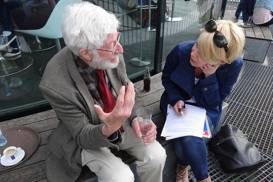 Ein älterer Herr unterhält sich mit einer jungen Frau