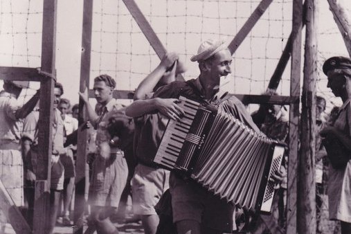 Ein Mann spielt während er geht Akkordeon