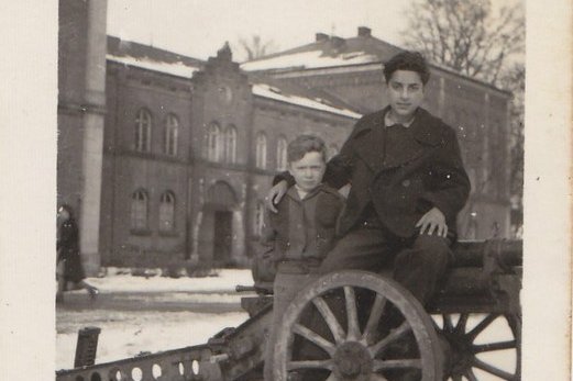 Zwei junge Burschen sitzen auf einer Kanone