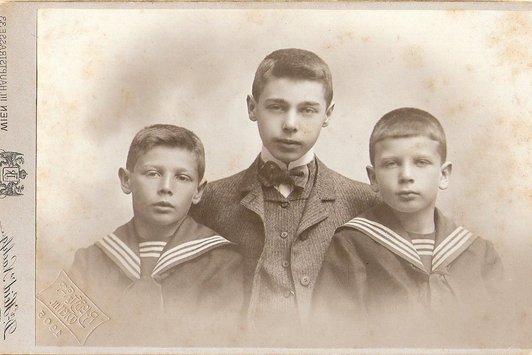 Zwei junge Buben und ein junger Erwachsener auf einem Gruppenfoto