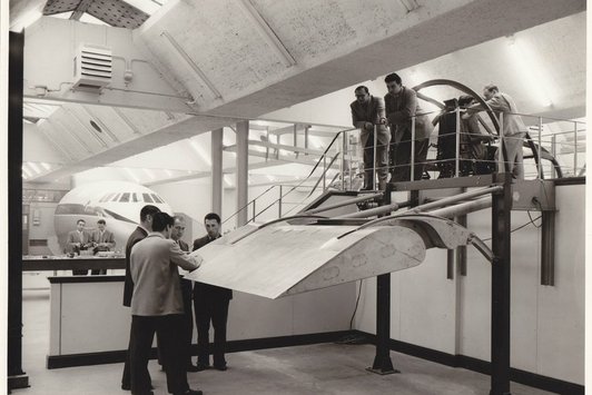 Einige Männer stehen bei einer Flugzeugtragfläche