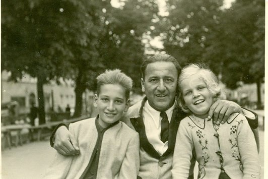 Ein Vater hält seine zwei Kinder im Arm für ein Foto