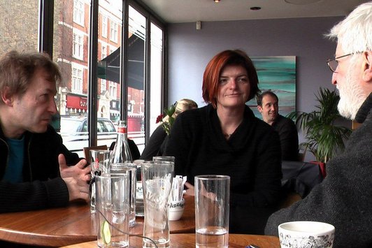 Drei Personen sitzen in einem Restaurant gemeinsam zu Tisch