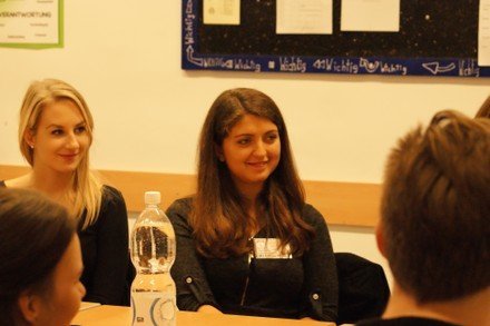 Mädchen sitzen an einem großen Tisch