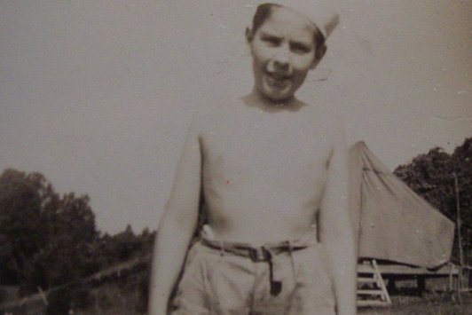 Foto eines jungen Burschen, oberkörperfrei mit Feldmütze