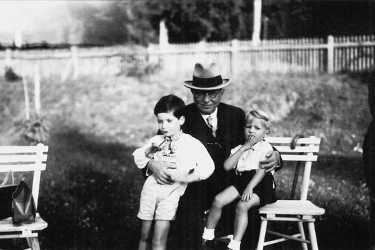 Ein älterer Herr hält zwei Kinder in den Armen