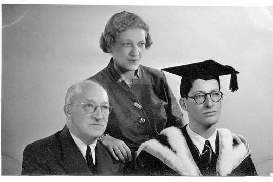 Zwei Eltern und ihr Sohn bei dessen Studienabschluss