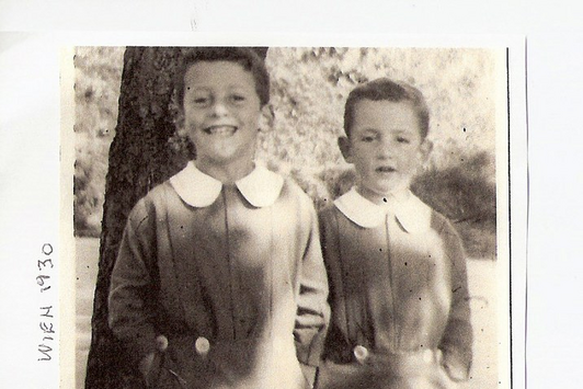 Zwei junge Burschen stehen vor einem Baum und lachen