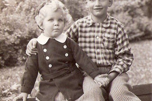 Zwei Kinder sitzen auf einer Parkbank