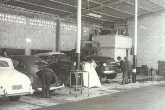 Einige Menschen arbeiten an Autos in einer Werkstatt