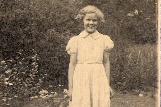 Ein junges Mädchen steht auf einer Wiese