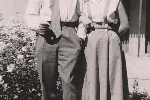 Ein Foto einer Frau und eines Mannes, die nebeneinander vor einem Haus stehen