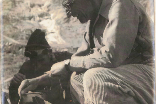 Ein älterer Mann beim Kochen in den Bergen