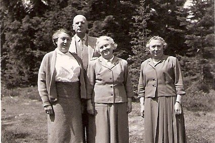 Vier Personen stehen zusammen auf einer Wiese