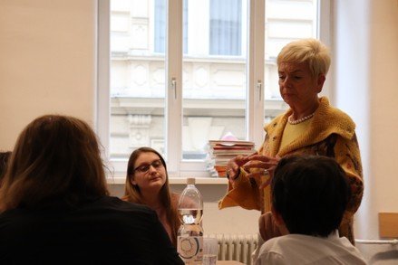 eine ältere Dame spricht mit jungen Personen