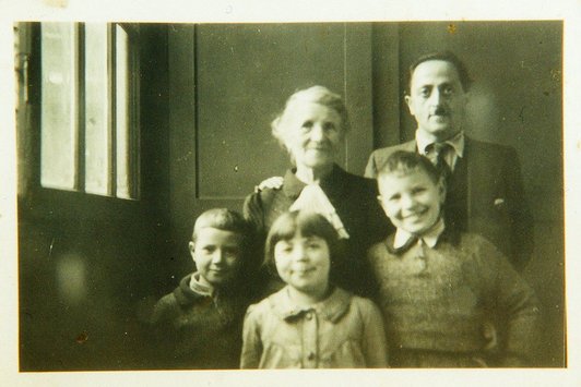Ein Familienfoto, drei junge Kinder mit einem Herrn und einer älteren Dame sind zu sehen
