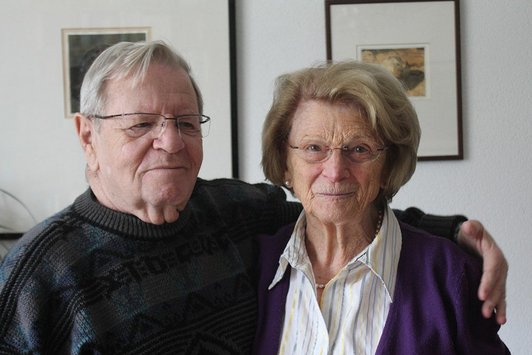 Ein älterer Herr umarmt eine ältere Dame