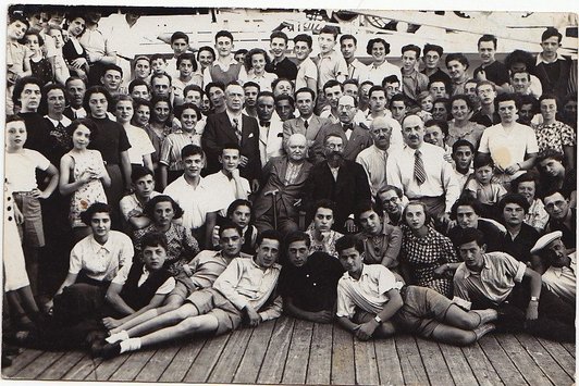 Eine große Gruppe Menschen steht auf dem Deck eines Schiffs